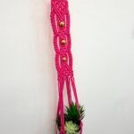 A macrame wall hanging in hot pink A macrame wall hanging in hot pink